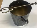 a metal bucket with a spoon in it sitting on a table