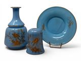 two vases and a plate sitting next to each other