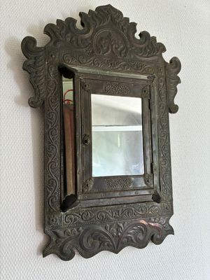 un miroir accroché au mur dans lequel on voit un livre