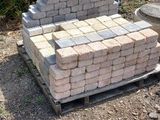 a pile of bricks sitting on a pallet in the middle of a field