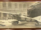 photo encadrée représentant un vieil avion à l'intérieur d'un bâtiment, avec une foule de personnes