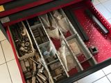 une boîte à outils contenant des outils, posée sur un sol carrelé