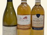 three bottles of wine sitting next to each other on a white surface