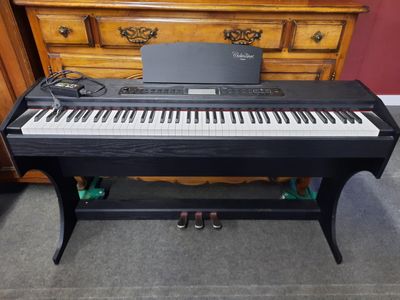un piano posé par terre devant une commode
