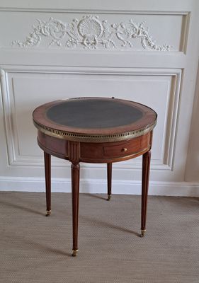 une petite table avec un plateau en verre, posée sur un sol recouvert de moquette