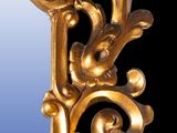 a mirror that has a gold frame with flowers on it