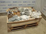 a wooden crate filled with assorted metal items on the floor