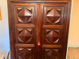 a wooden armoire with many drawers and doors on it