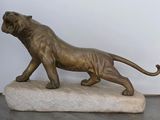 statue en bronze représentant un lion perché sur un rocher, dans une pièce