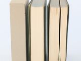 three books are stacked on top of each other on a white surface