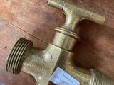 a brass faucet on a wooden table with a sticker on it