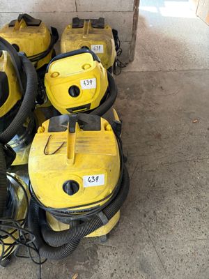 several yellow vacuum cleaners are lined up on the floor