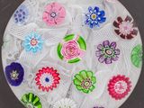 une assiette en verre décorée de fleurs, posée sur une table
