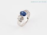 a white gold ring with a blue sapphire and baguets