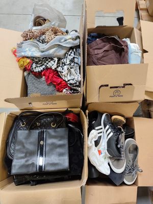 une boîte remplie de vêtements et de chaussures posée par terre