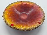 a red and yellow bowl sitting on a white table