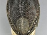 a close up of a fencing mask on a white surface