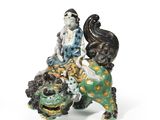 a figurine of a woman sitting on top of a lion