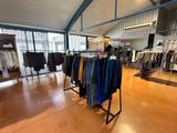 a lot of clothes hanging on racks in a store