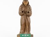 wooden statue of a monk with a green plaque in front of a white background