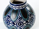a blue and white vase sitting on a white surface