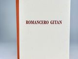a close up of a white book with red writing on it