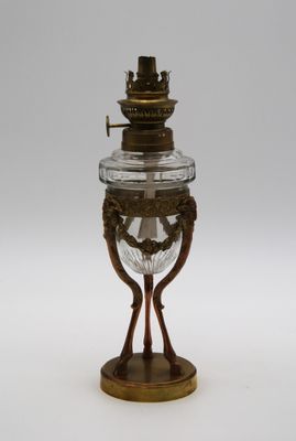 une lampe à huile ancienne en laiton et en verre sur fond blanc