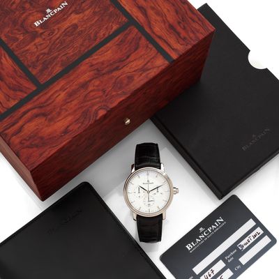 un gros plan sur une montre, un portefeuille et une carte bancaire posés sur une table
