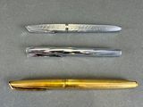 three different types of pens are lined up on a table