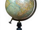 un petit globe terrestre posé sur un socle, sur fond blanc