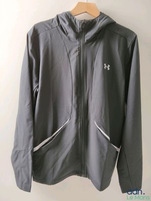 un gros plan sur une veste grise accrochée à un mur