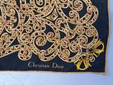 a close up of a black and gold scarf with a yellow bow