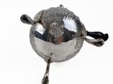 a silver plate with a bird on it on a white surface