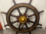 a ship wheel with a golden center on the wall