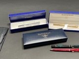 three pens and a pen in a case on a table