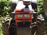 a tractor that is parked in the grass with a sign on it