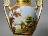 a vase with a painting on it sitting on a table
