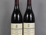 two bottles of wine sitting on top of a table next to each other