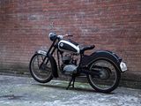 a motorcycle that is parked next to a brick wall