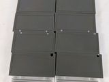 un gros plan sur une pile de lecteurs de disquettes posés sur une surface blanche