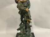 statue en bronze représentant un homme tenant un enfant sur un rocher