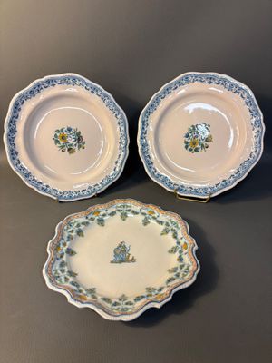 three plates with floral designs on them sitting on a table