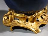 a blue vase with a gold decoration on it