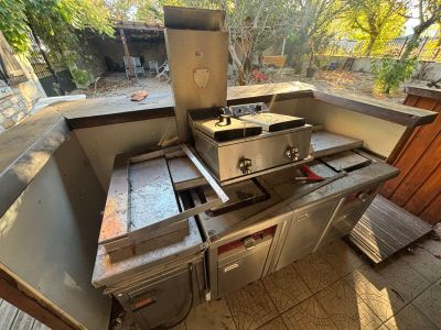 une cuisine d'extérieur équipée d'un barbecue et d'un évier