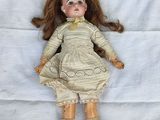a doll that is laying down on a white sheet