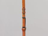 an image of a wooden flute on a clear stand