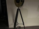 a lamp that is on a tripod stand in a room
