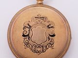 a gold colored pocket watch with a crown on it
