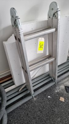 a ladder leaning against a wall with a yellow sticker on it
