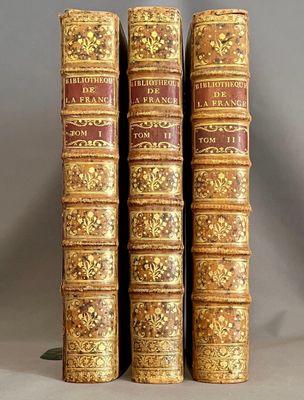 trois vieux livres sont empilés sur une table